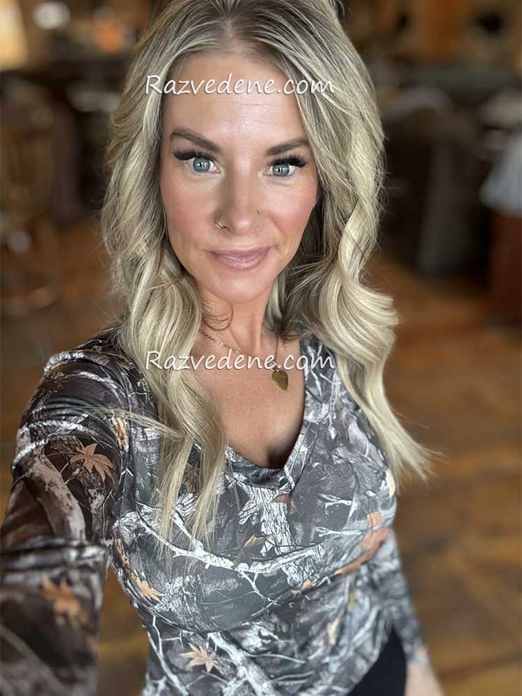 žena plave kose u bluzici sa šarom blagi osmeh