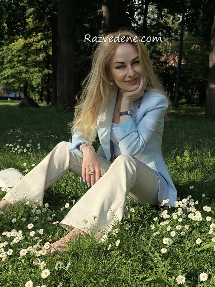 žena sedi u prirodi među cvećem